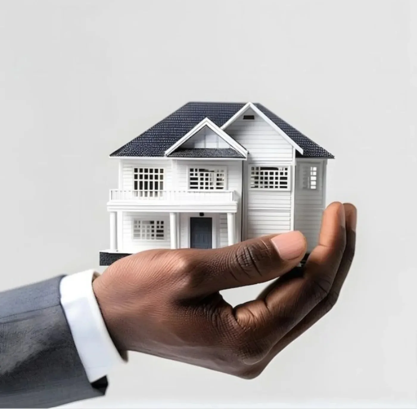 A hand holding a model home, representing the homes Kabom Developers helps create
